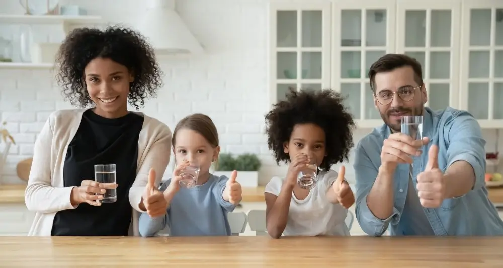 Portrait of multiracial family with kids drink water